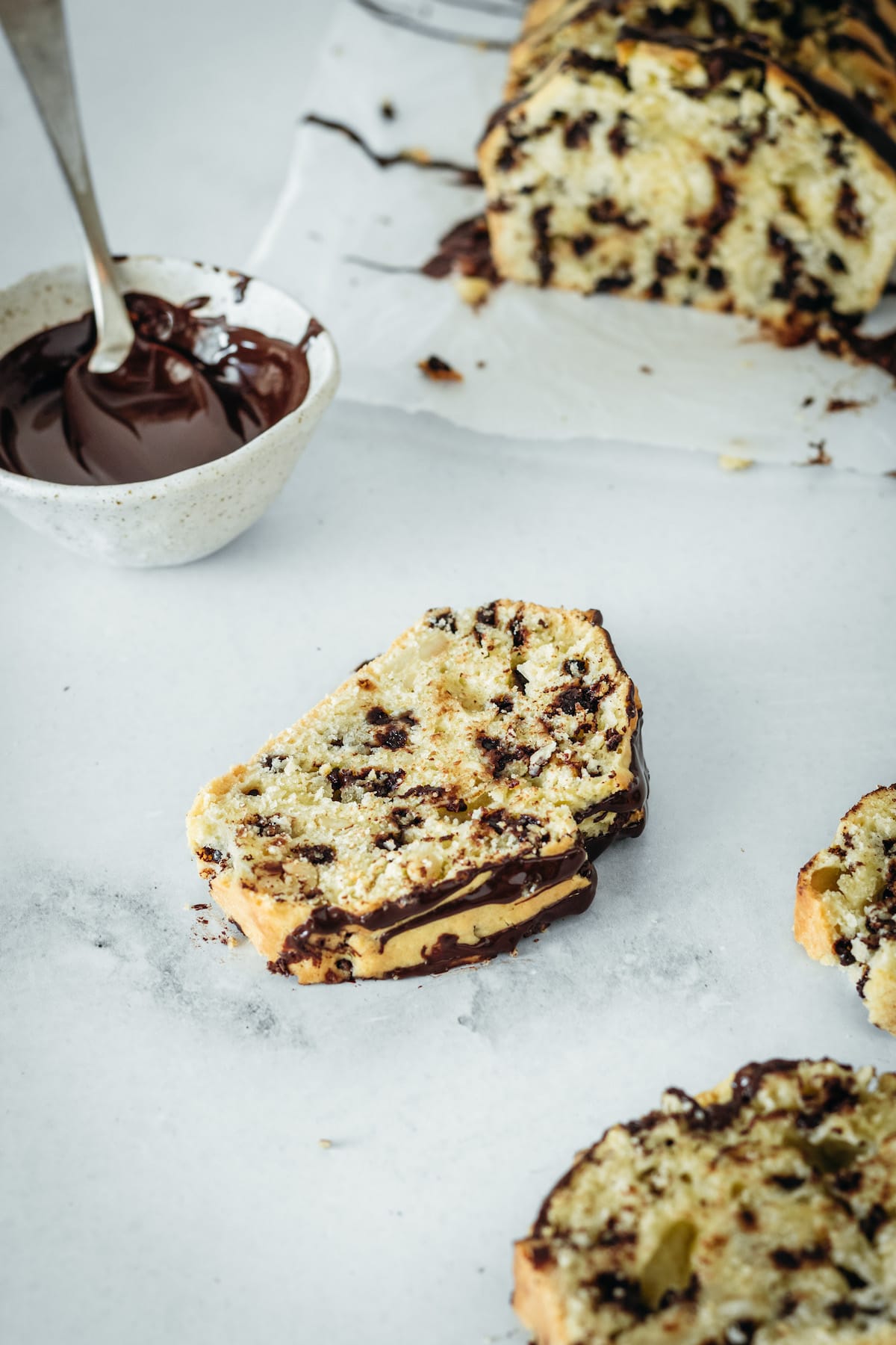 Slice of chocolate chip cashew bread on marble slab