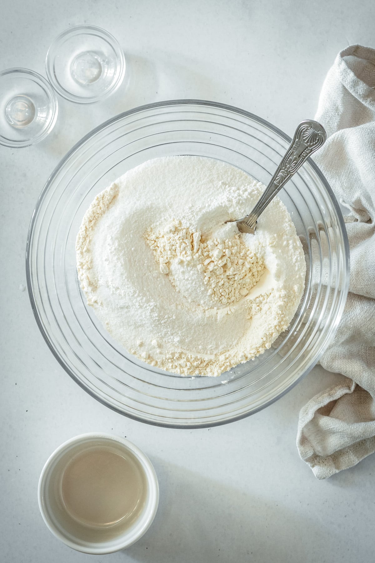 Overhead view of dry ingredients in glass mixing bowl