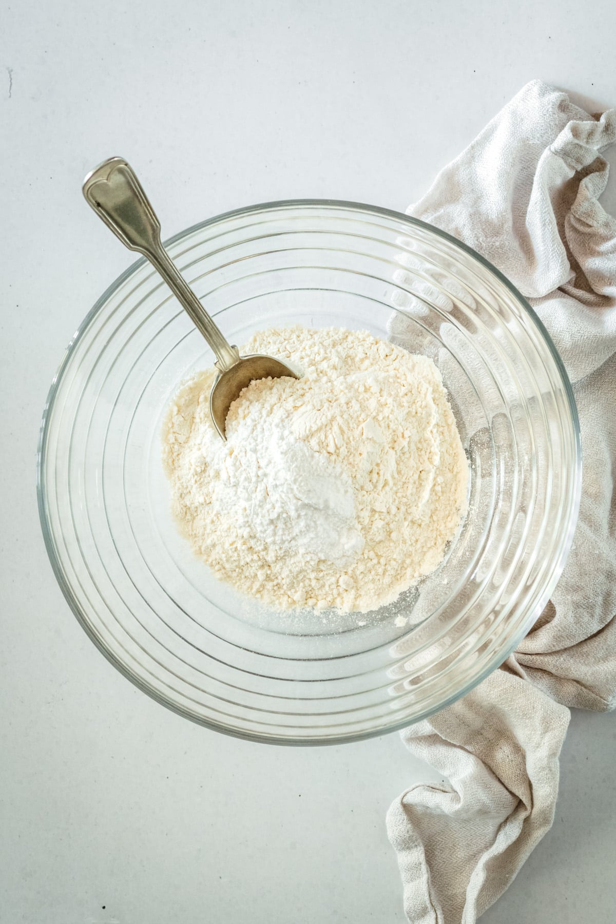 Overhead view of dry coffee cake ingredients in glass mixing bowl