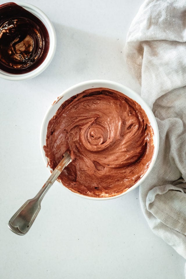 Overhead view of chocolate cake batter in small bowl with spoon