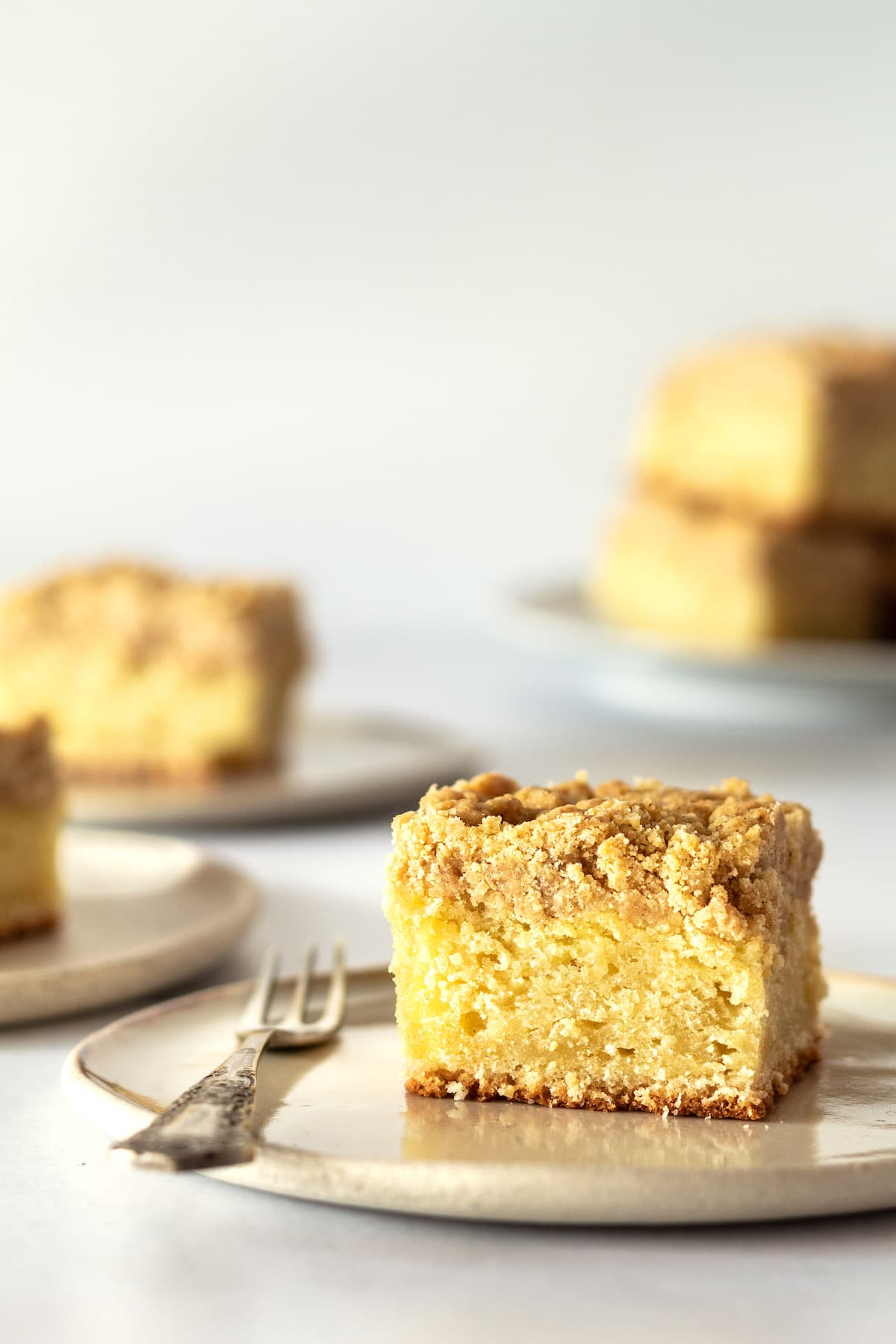 Side view of crumb cake on plate with fork