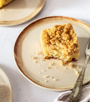 Square of crumb cake on small plate with fork