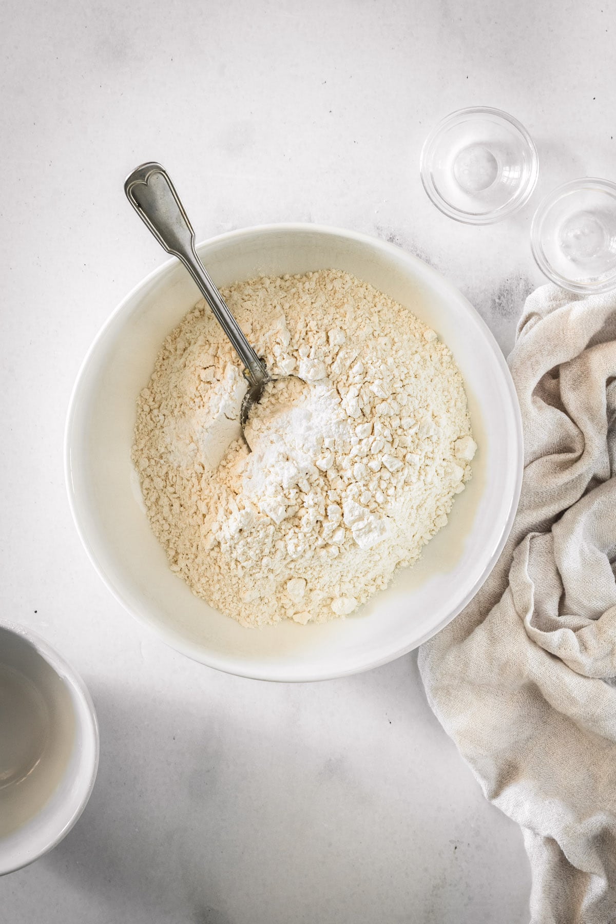 Overhead view of dry ingredients for cake in bowl with spoon