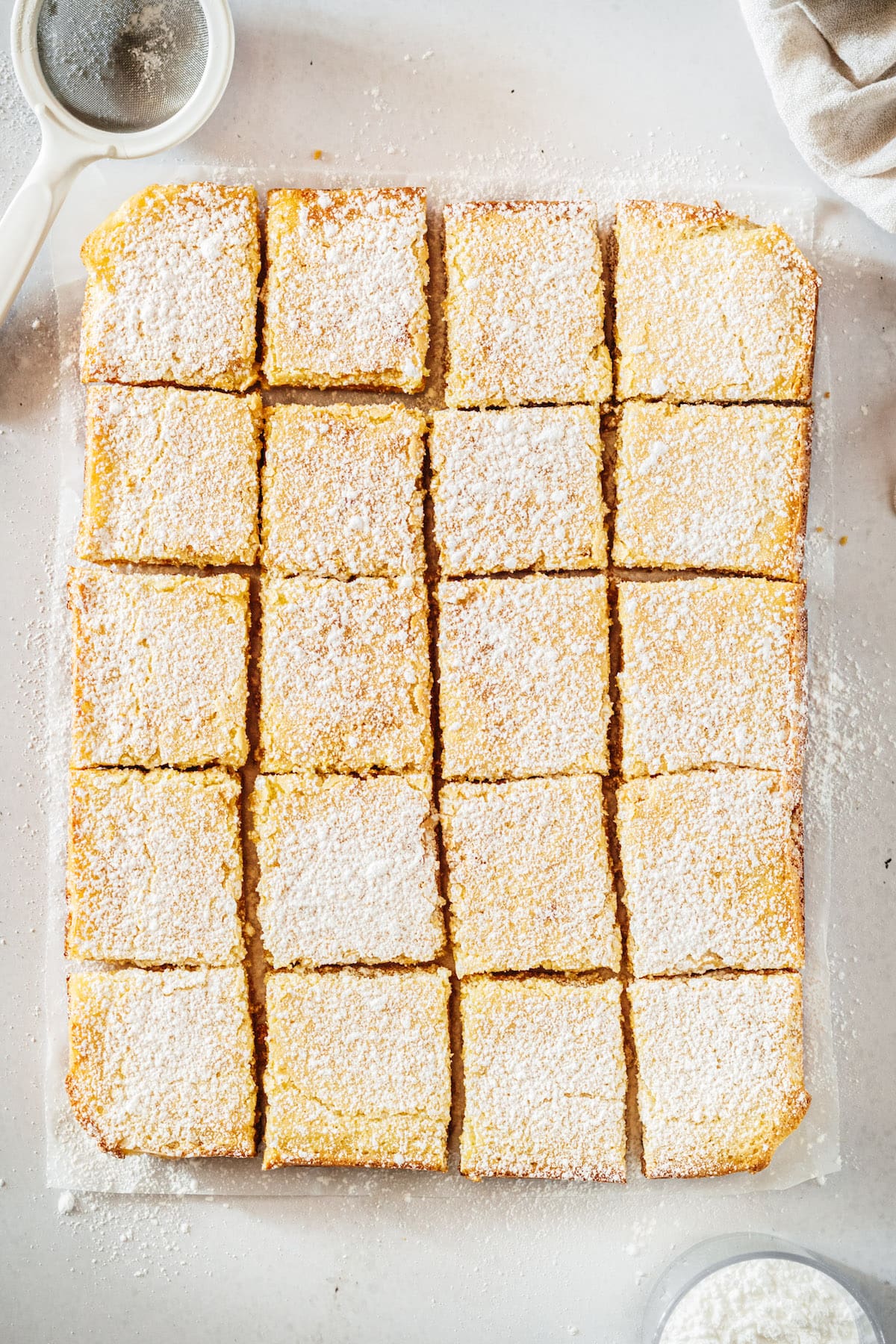 Overhead view of cut lemon bars on parchment paper