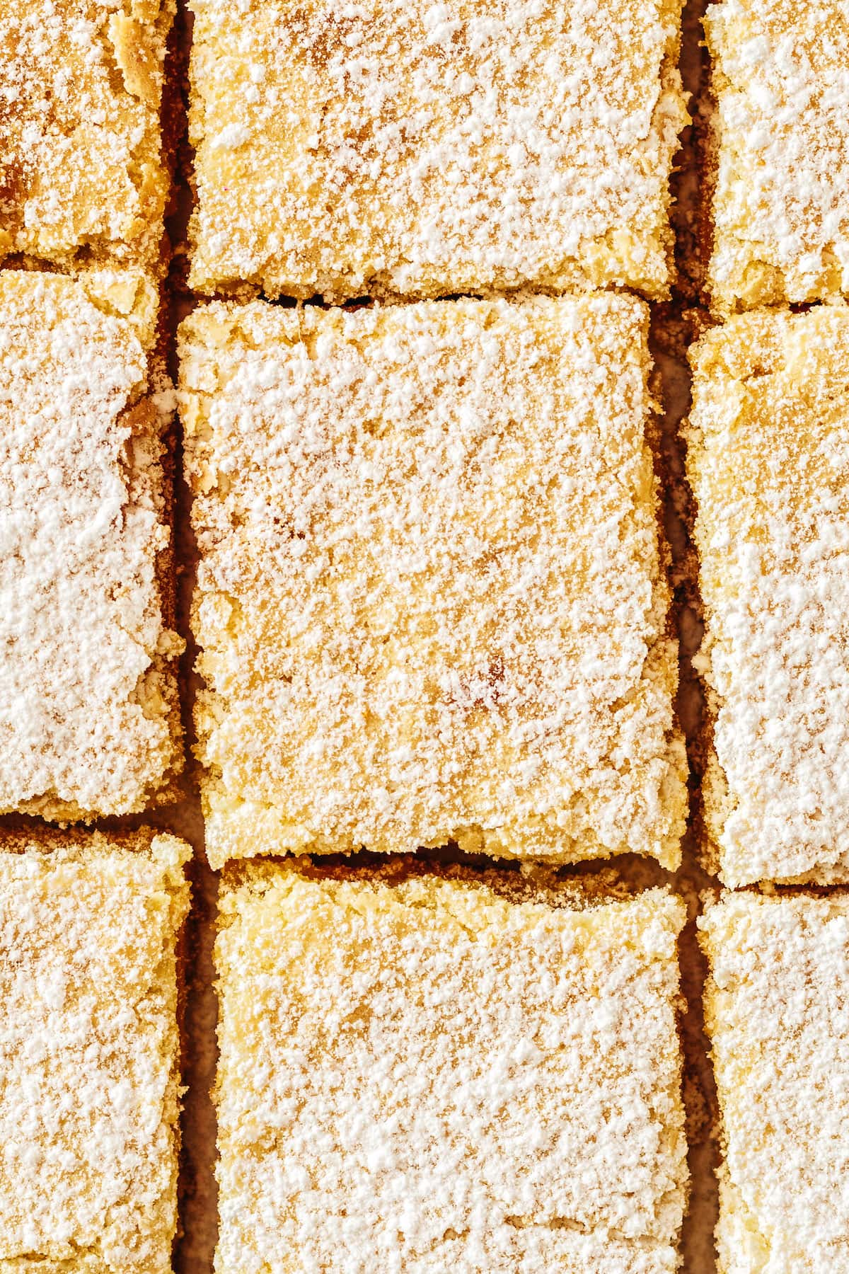 Overhead view of lemon bars dusted with powdered sugar after cutting