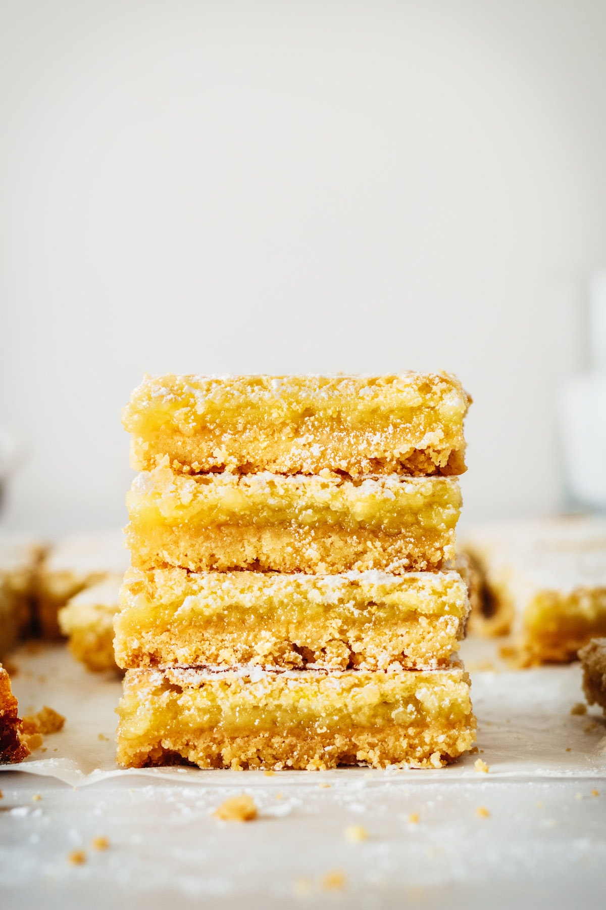 Stack of 4 lemon bars on parchment paper