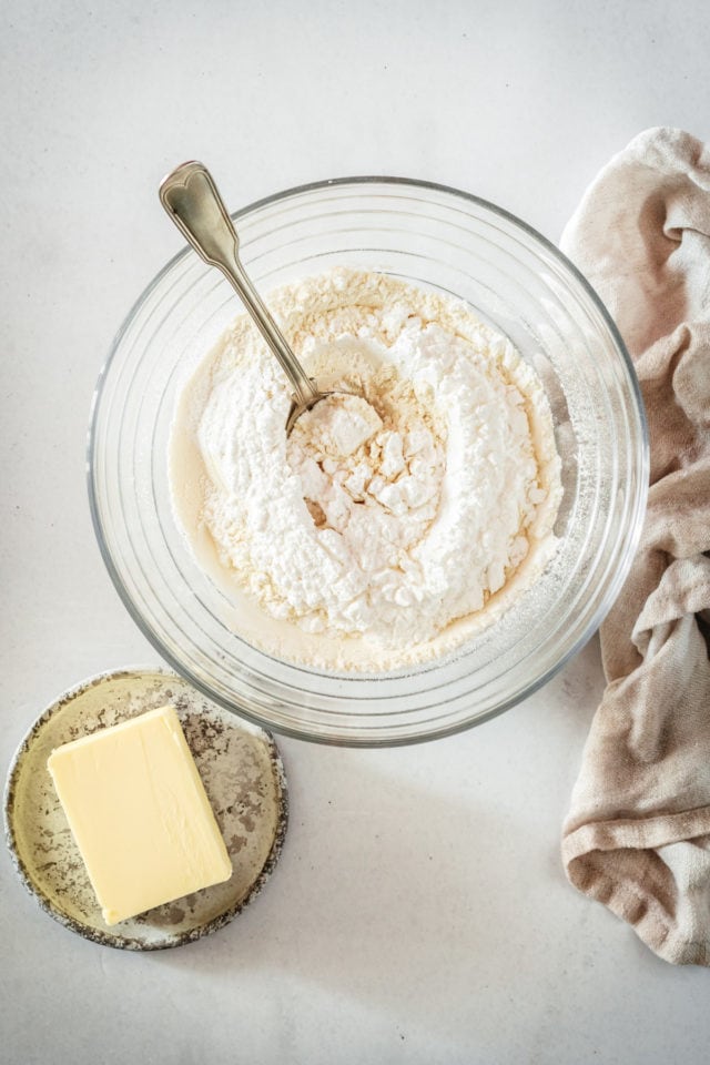 Overhead view of dry crust ingredients in mixing bowl with spoon