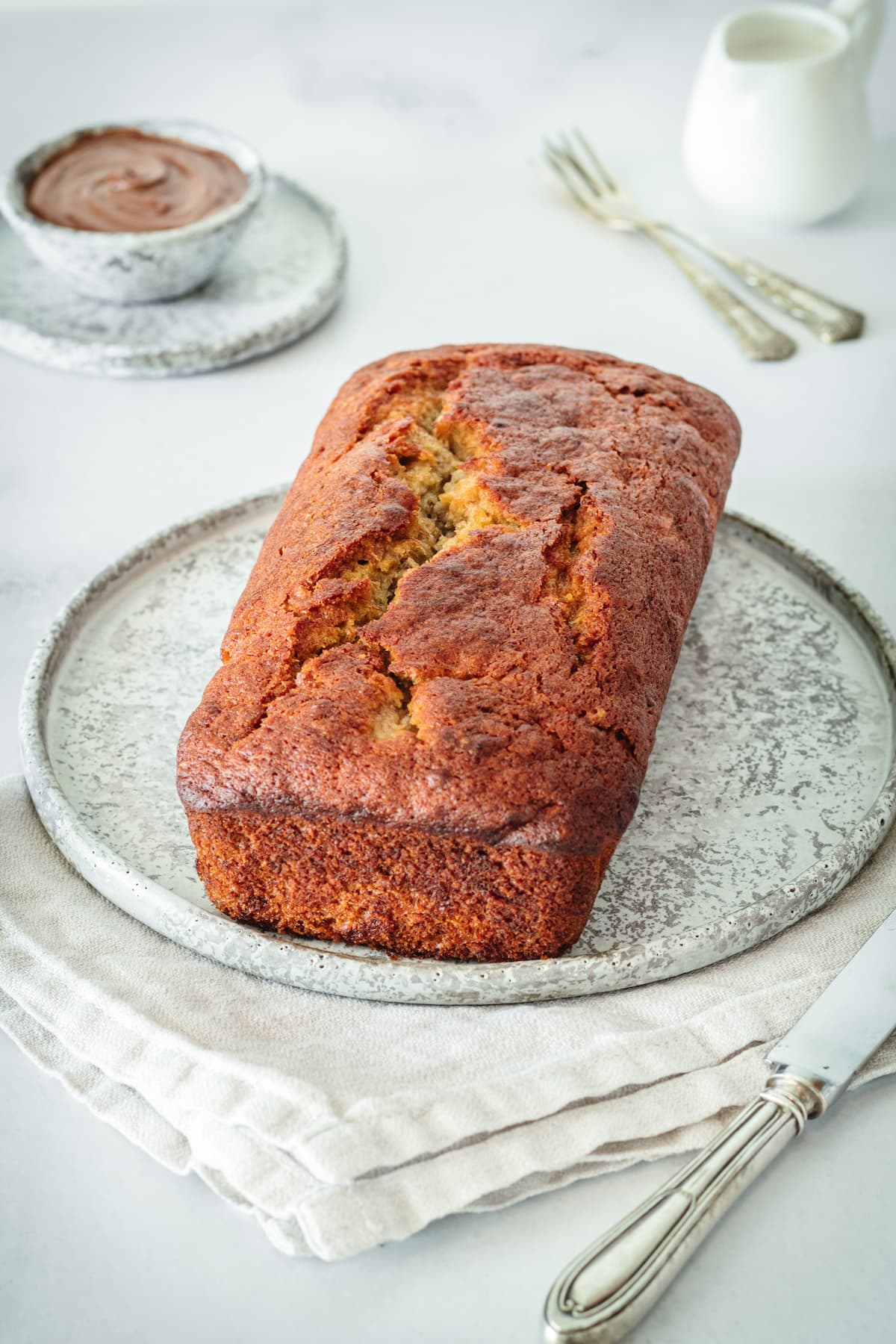 Whole loaf of Nutella banana bread on plate before cutting