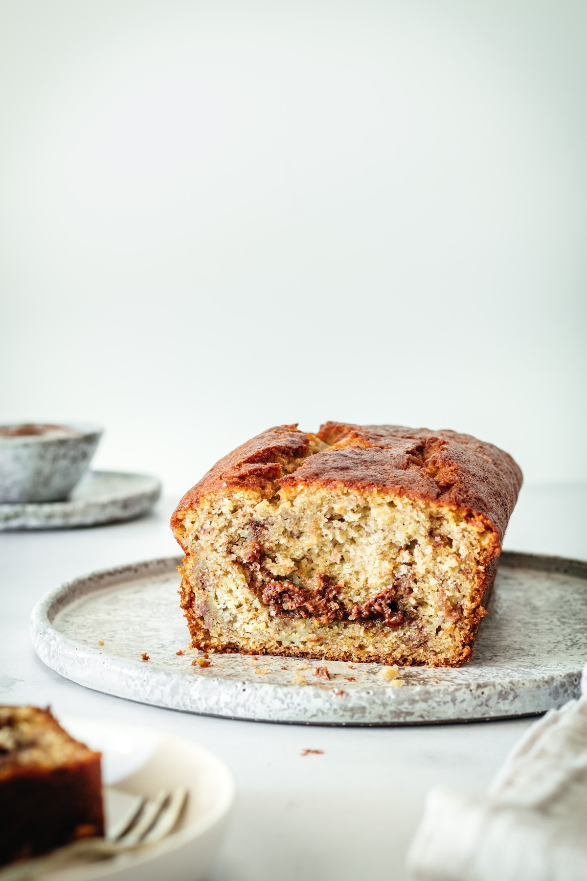 Loaf of banana bread on plate, cut to show inside