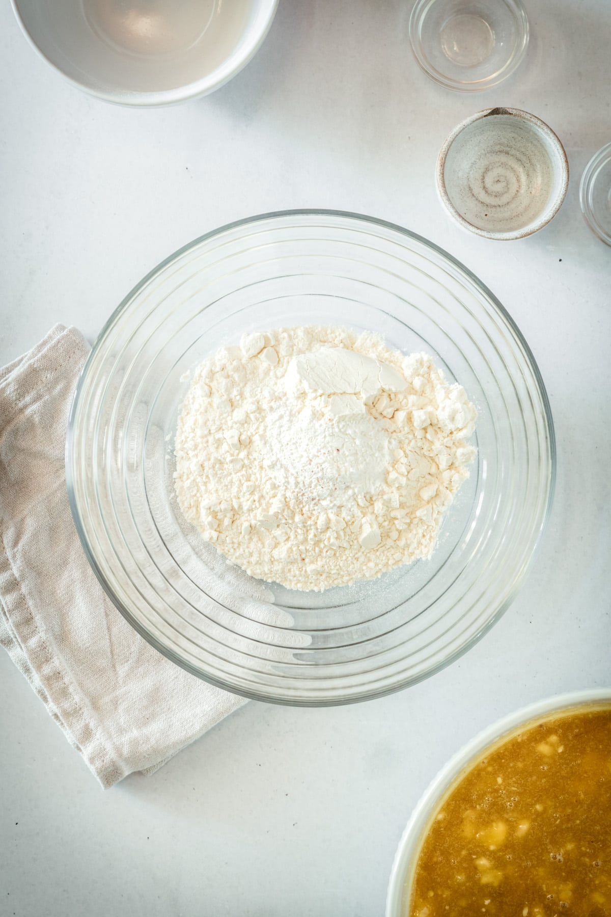 Overhead view of dry ingredients in glass mixing bowl