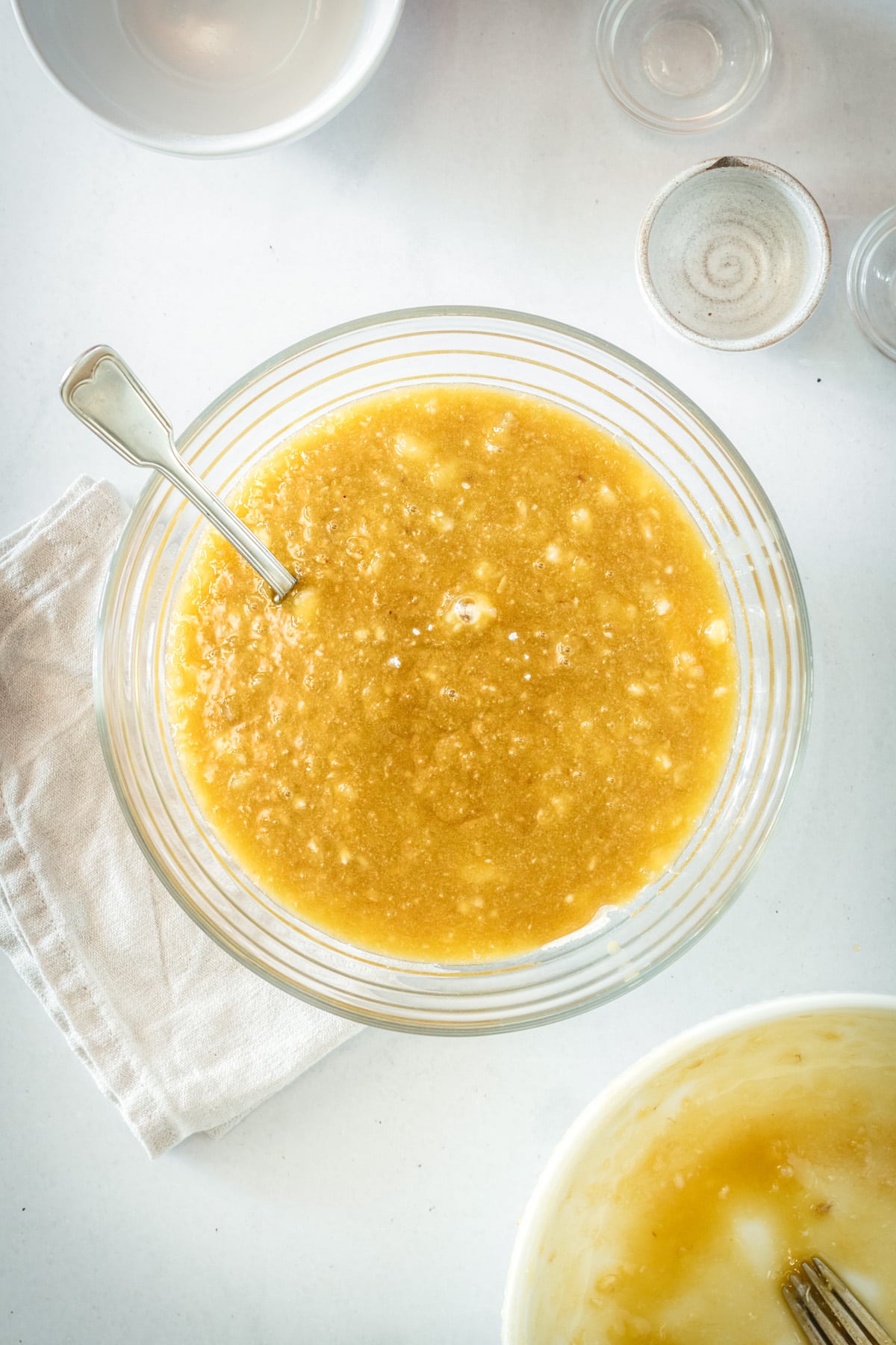 Overhead view of banana bread batter in glass mixing bowl