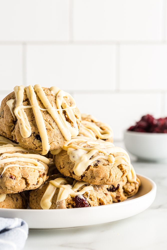 Oatmeal cranberry cookies piled on a white plate.