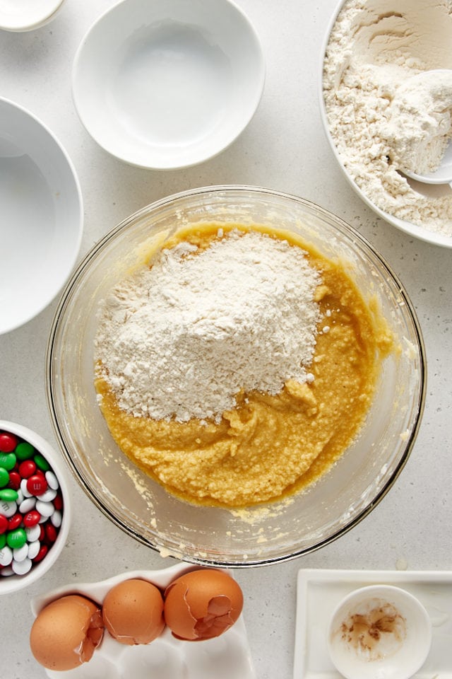 overhead view of dry ingredients added to wet ingredients for Christmas M&M Cookies