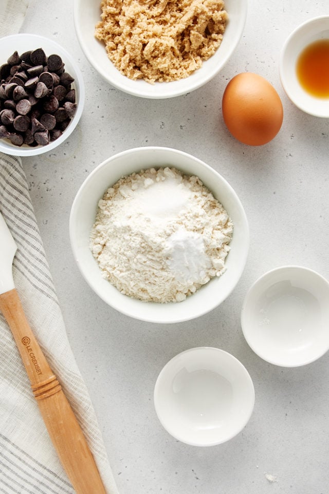 overhead view of flour, baking soda, and salt in a white mixing bowl