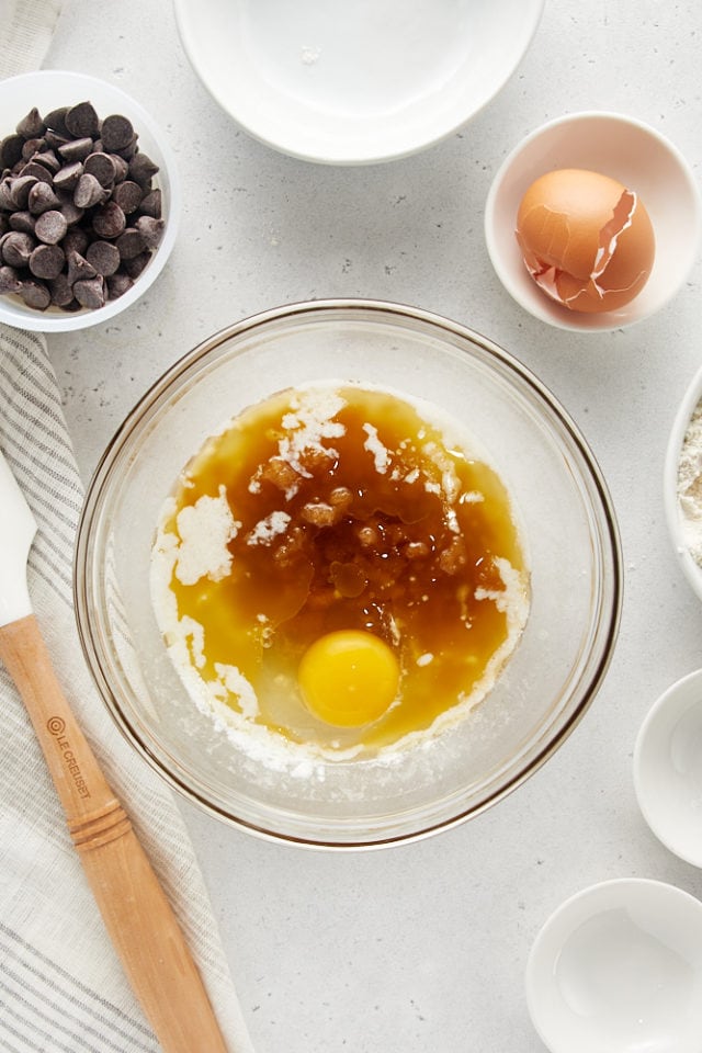 brown sugar, egg, and vanilla added to melted butter in a glass mixing bowl