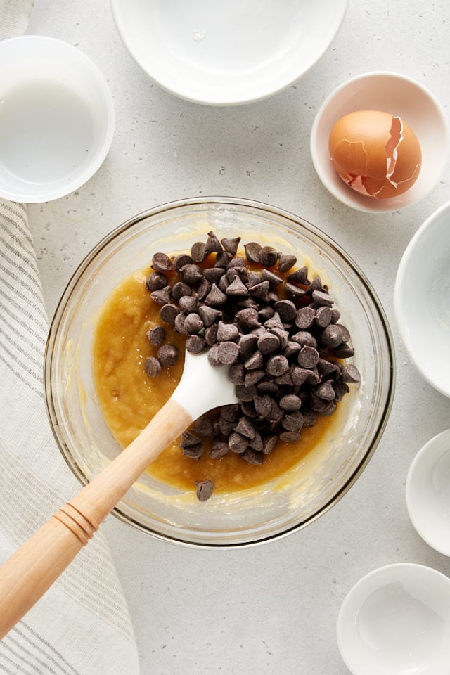 overhead view of chocolate chips added to cookie dough