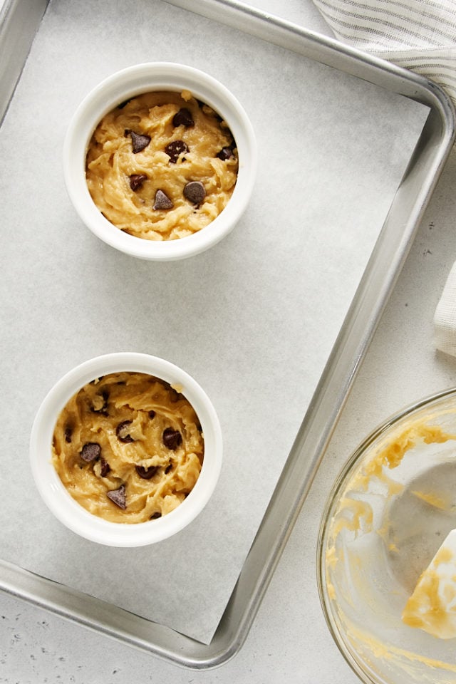 Deep Dish Chocolate Chip Cookies in two white ramekins ready to be baked