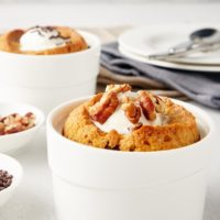 a Deep Dish Chocolate Chip Cookie topped with ice cream and nuts with another cookie in the background