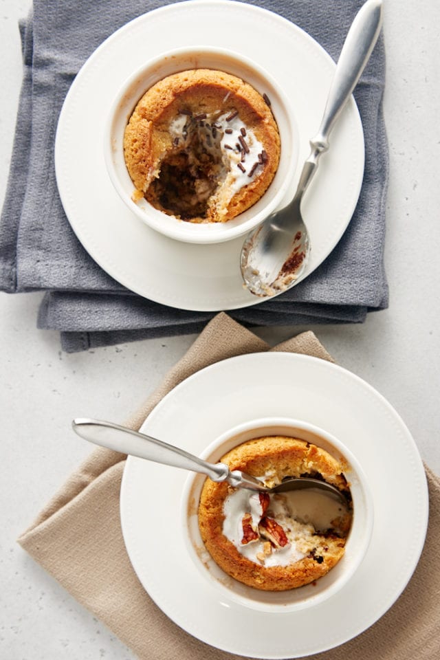 overhead view of Deep Dish Chocolate Chip Cookies for Two in white ramekins on white plates with gray and beige napkins underneath