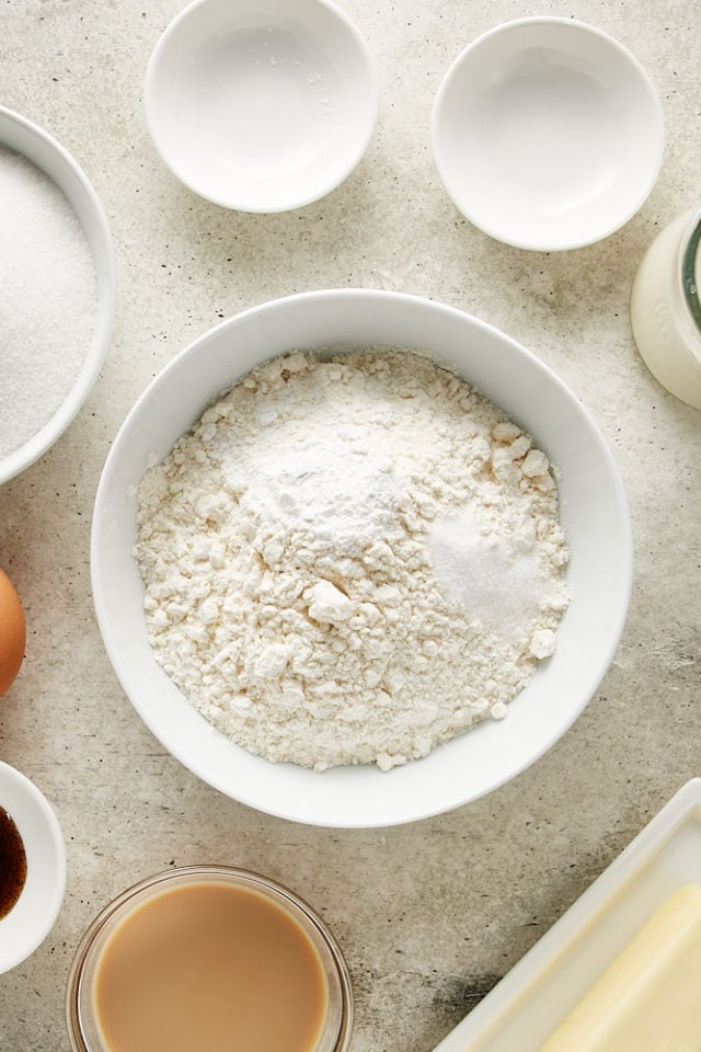 overhead view of cake flour, baking powder, and salt in a white mixing bowl