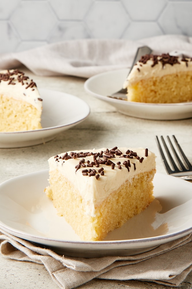 slice of Irish Cream Cake on a white plate with more servings in the background