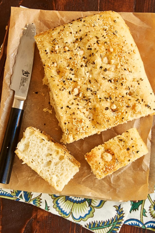overhead view of partially sliced No-Knead Focaccia on parchment paper