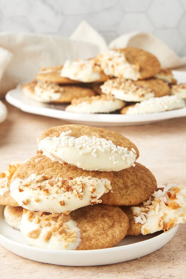 White Chocolate Snickerdoodles on a small white plate with more cookies on a large plate in the background