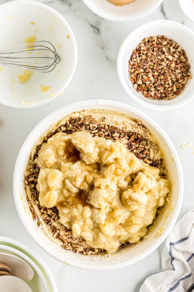 Overhead view of bananas and pecans before stirring into banana bread batter