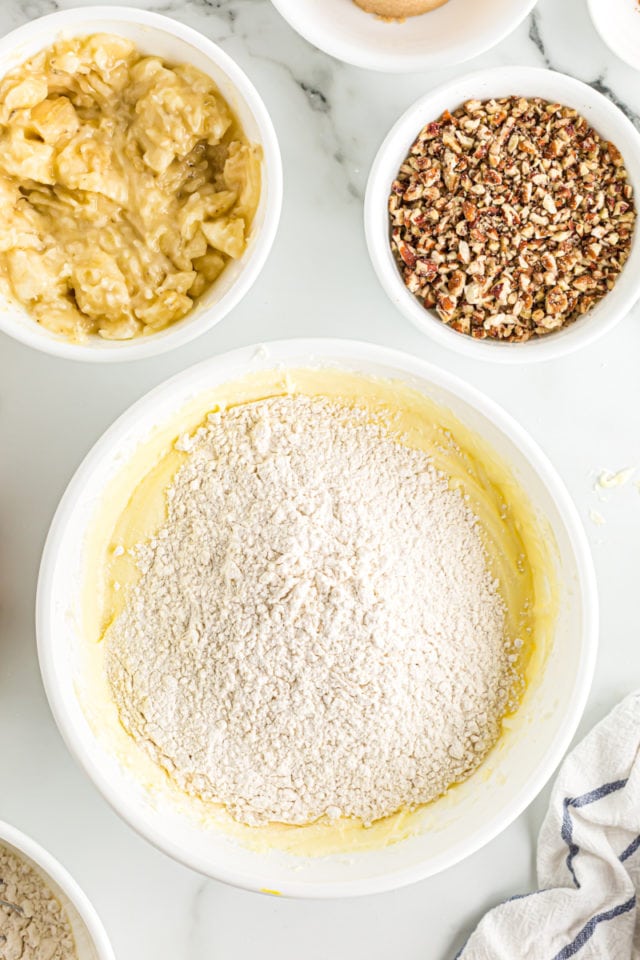 Overhead view of flour poured into mixing bowl with batter