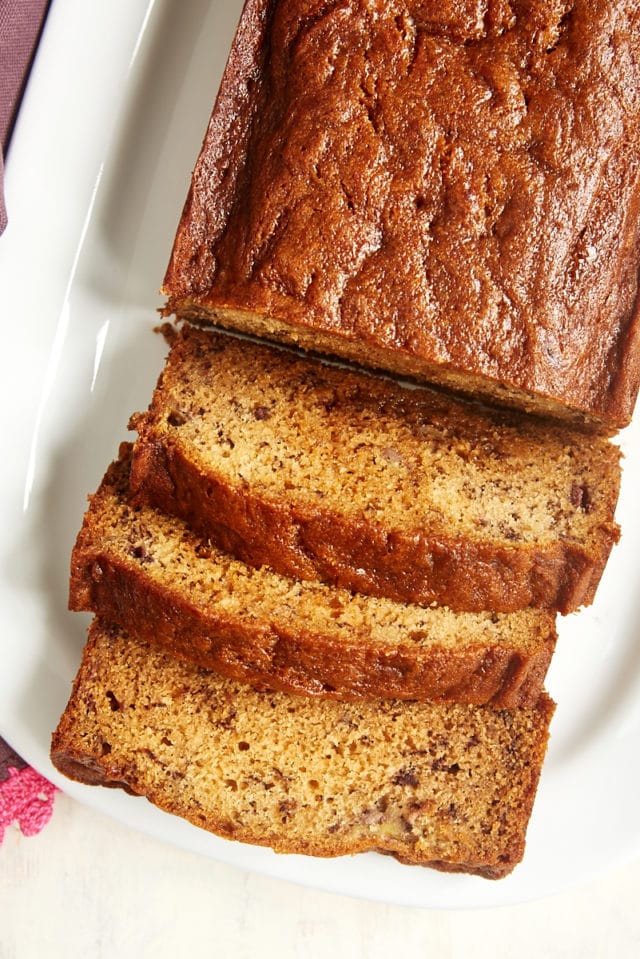 overhead view of partially sliced Dulce de Leche Banana Bread on a white serving tray