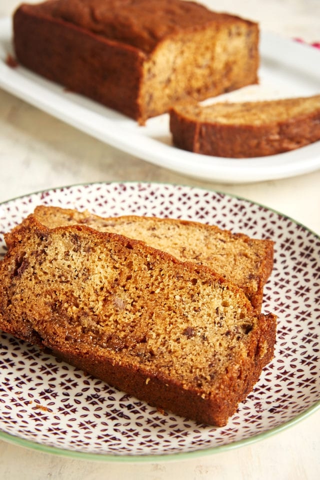 two slices of Dulce de Leche Banana Bread on a plate with the remaining loaf of bread in the background