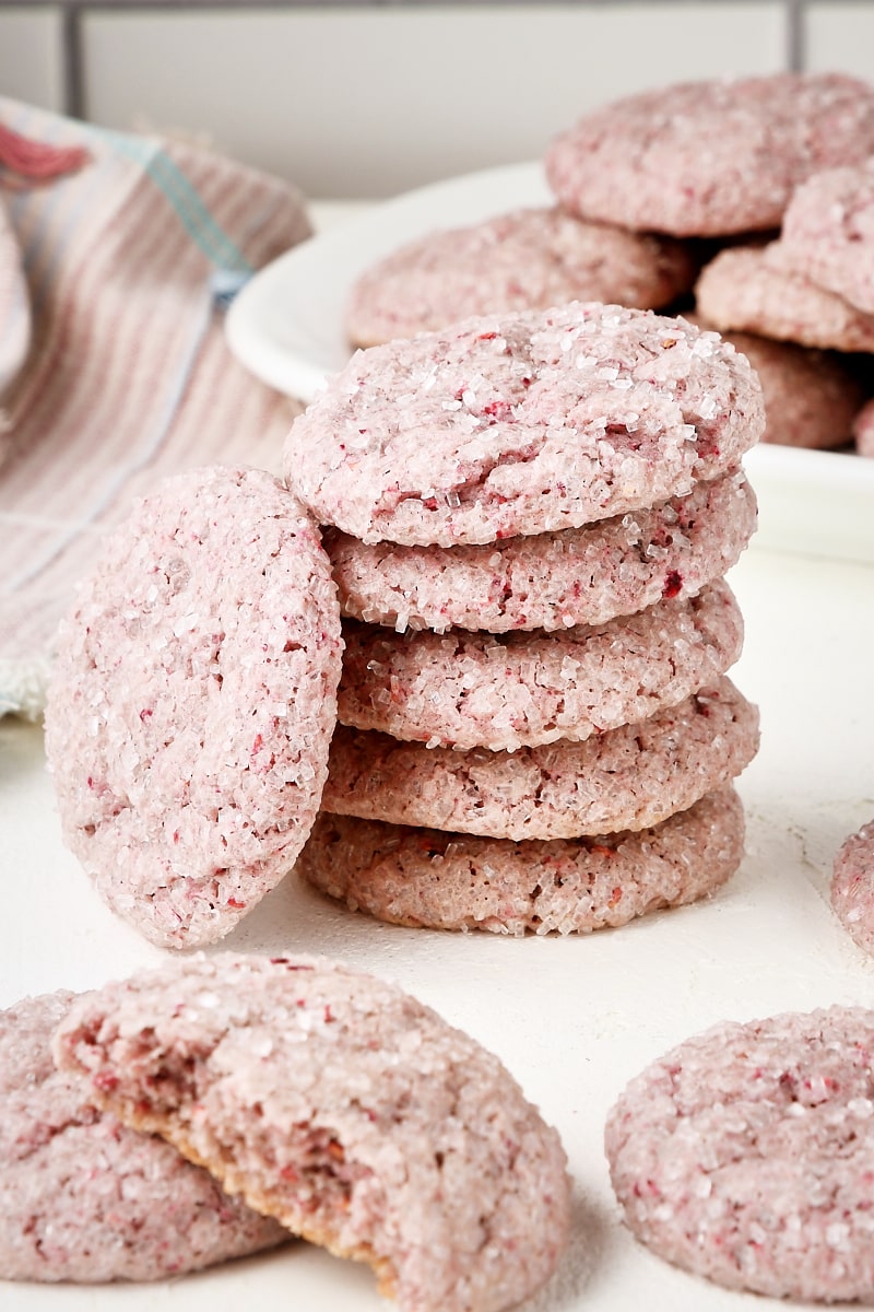 Stack of raspberry sugar cookies surrounded by more cookies.