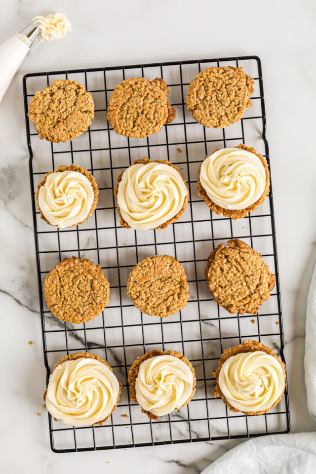 Overhead view of oatmeal cream pies on wire rack with half frosted