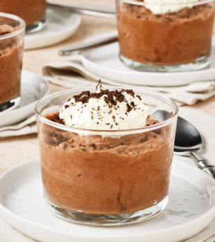 servings of Chocolate Mousse in clear glasses set on small white plates