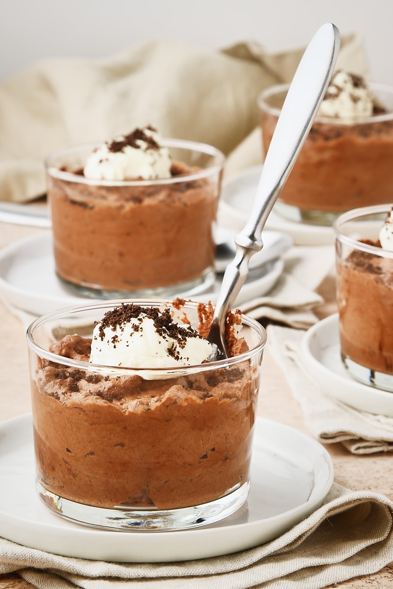 a serving of Chocolate Mousse with a spoon sticking out of it and more servings in the background