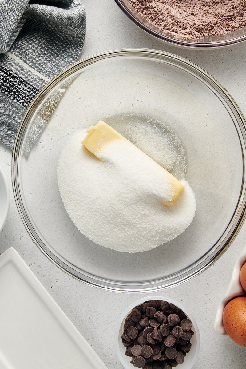 overhead view of sugar and butter in a glass mixing bowl