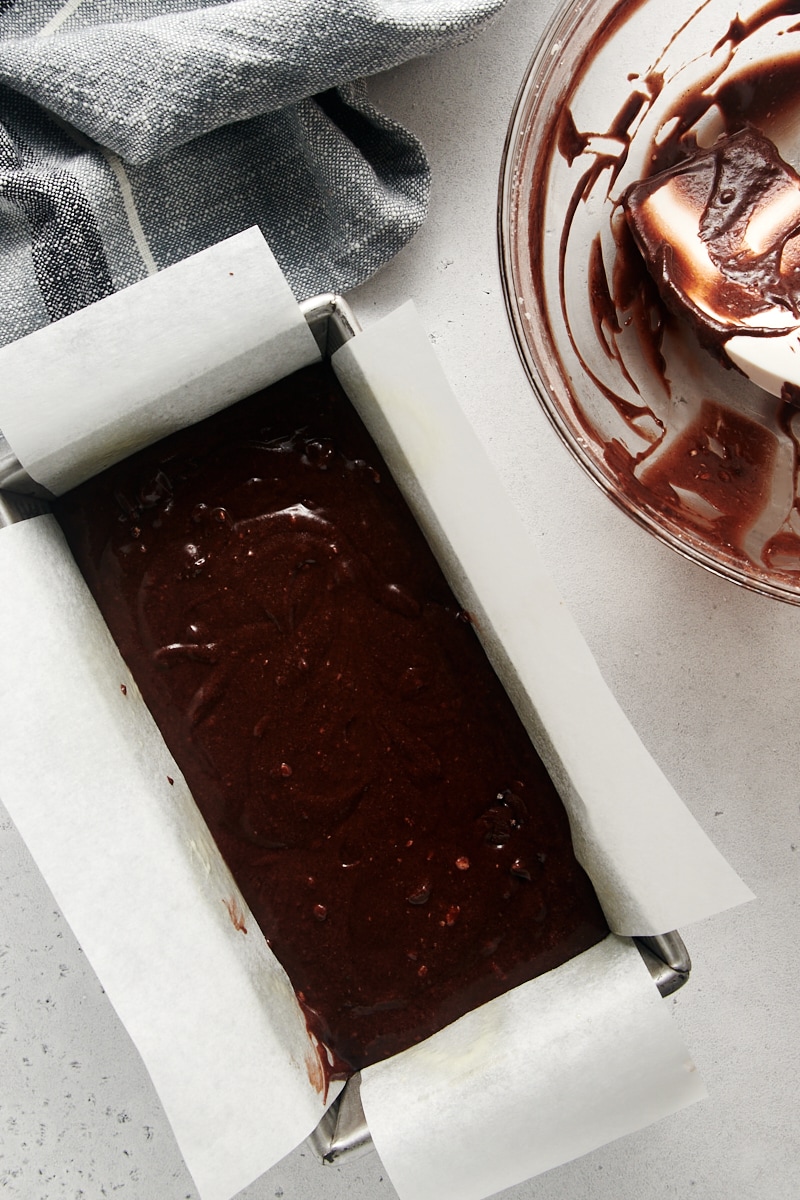 overhead view of Chocolate Loaf Cake batter in a parchment-lined loaf pan