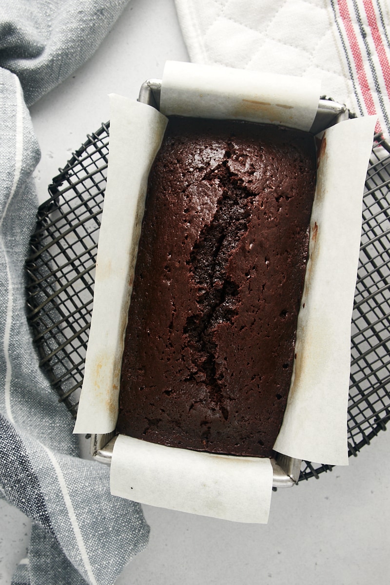 overhead view of freshly baked Chocolate Loaf Cake in a loaf pan on a wire rack