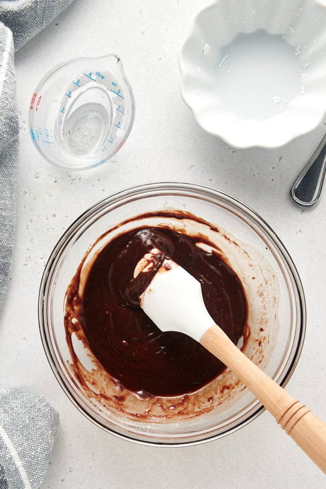 overhead view of mixed chocolate glaze in a glass mixing bowl