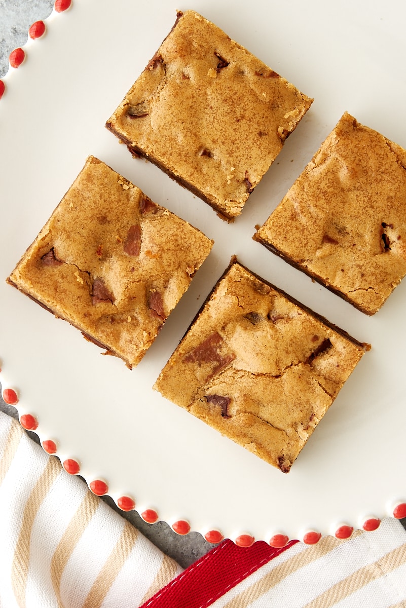 overhead view of four Double Chocolate Chunk Blondies on a red-rimmed white plate