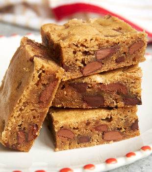 stack of Double Chocolate Chunk Blondies on a red-trimmed white plate