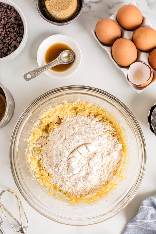 Overhead view of dry ingredients added to wet ingredients in mixing bowl