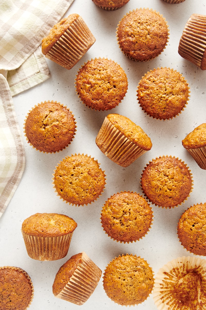 overhead view of banana nut muffins scattered on a white surface