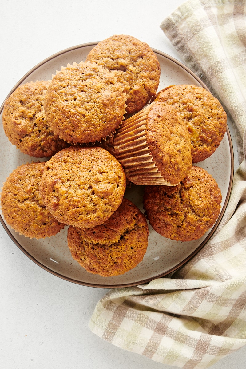 overhead view of Banana Nut Muffins piled on a white and brown speckled plate