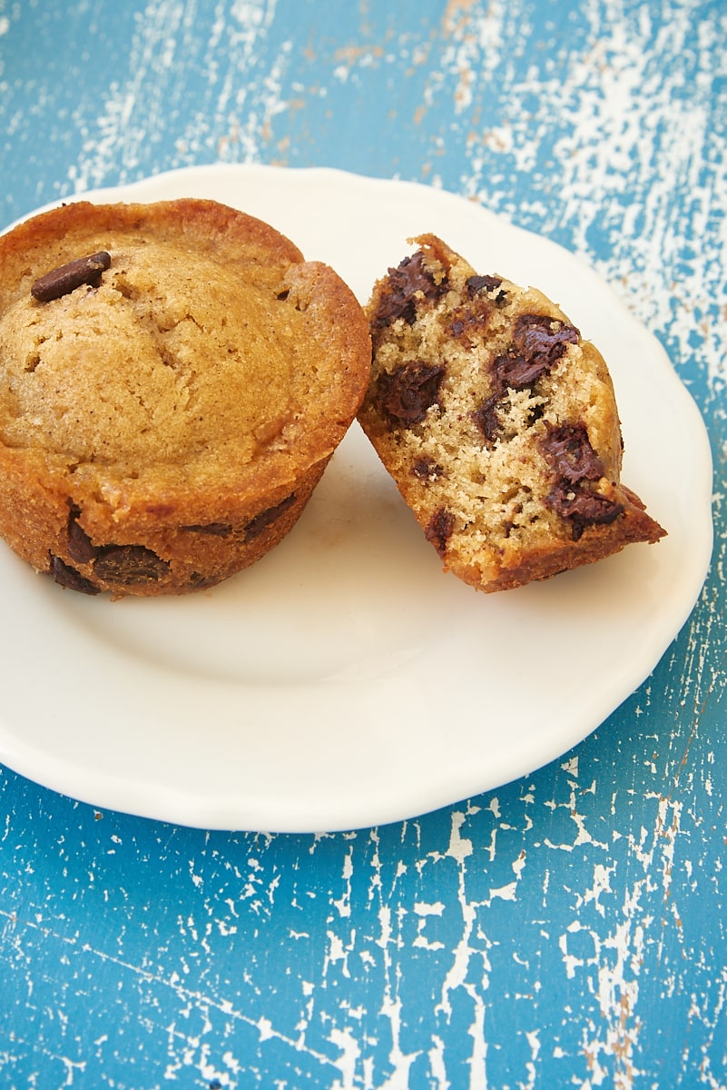 a whole and a partial Chocolate Chip Muffin on a white plate