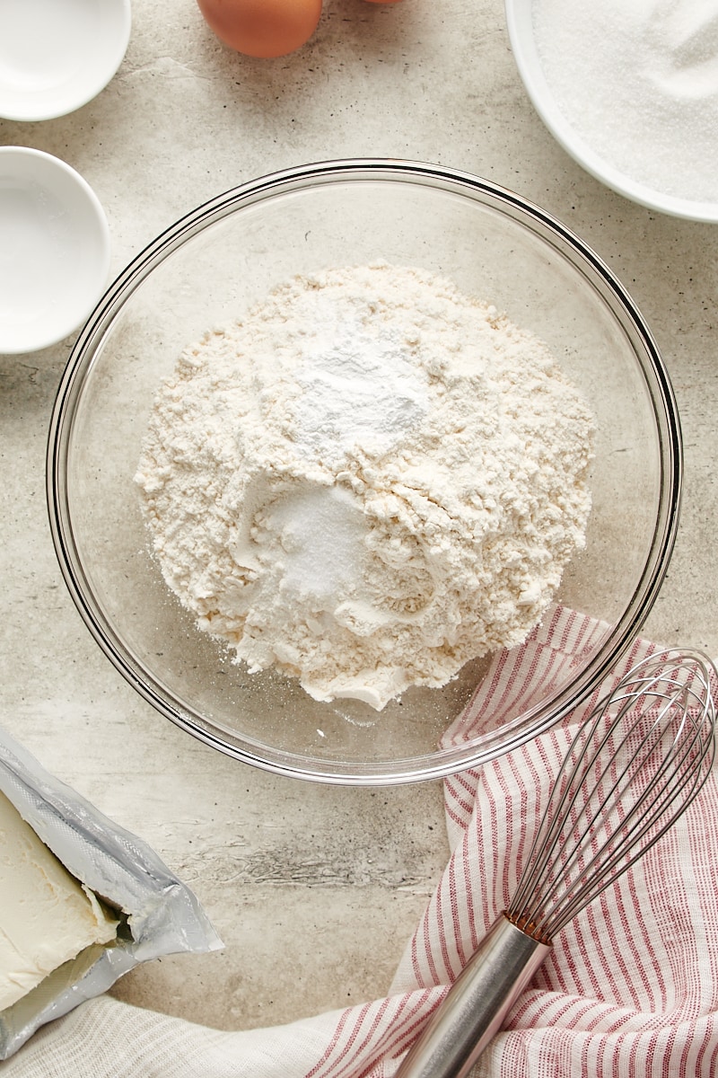 overhead view of flour, baking powder, and salt in a glass mixing bowl