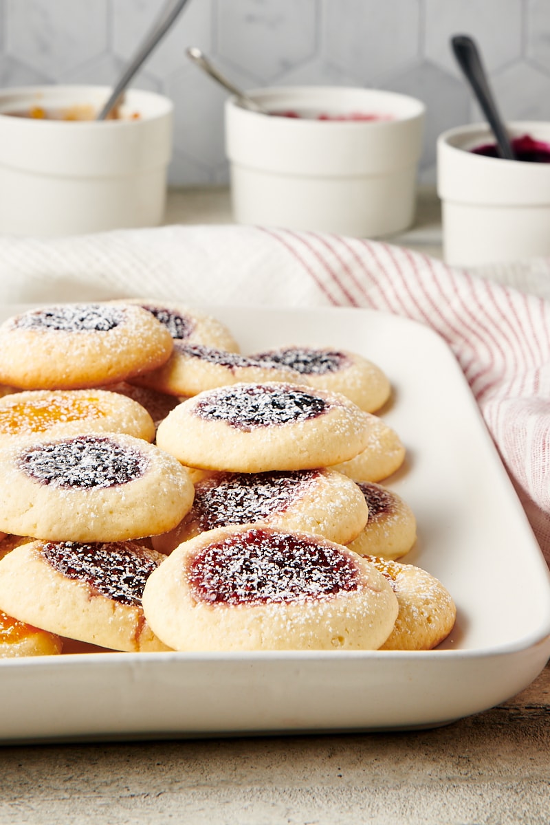 Cream Cheese Thumbprint Cookies piled on a white serving tray