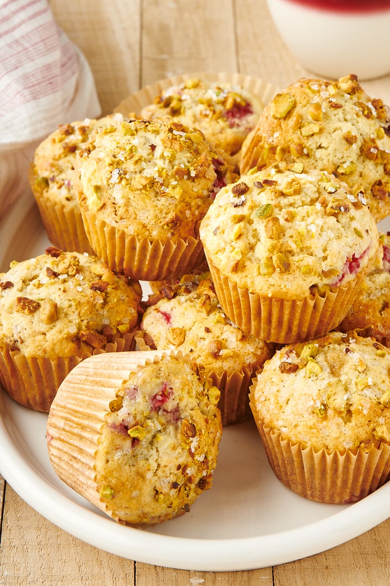 Raspberry Pistachio Muffins piled on an oval white platter