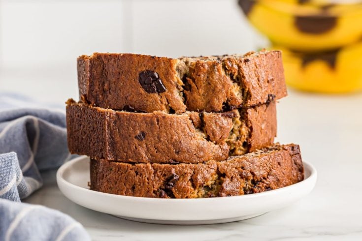 Three pieces of Chocolate Chunk Banana Bread stacked on plate