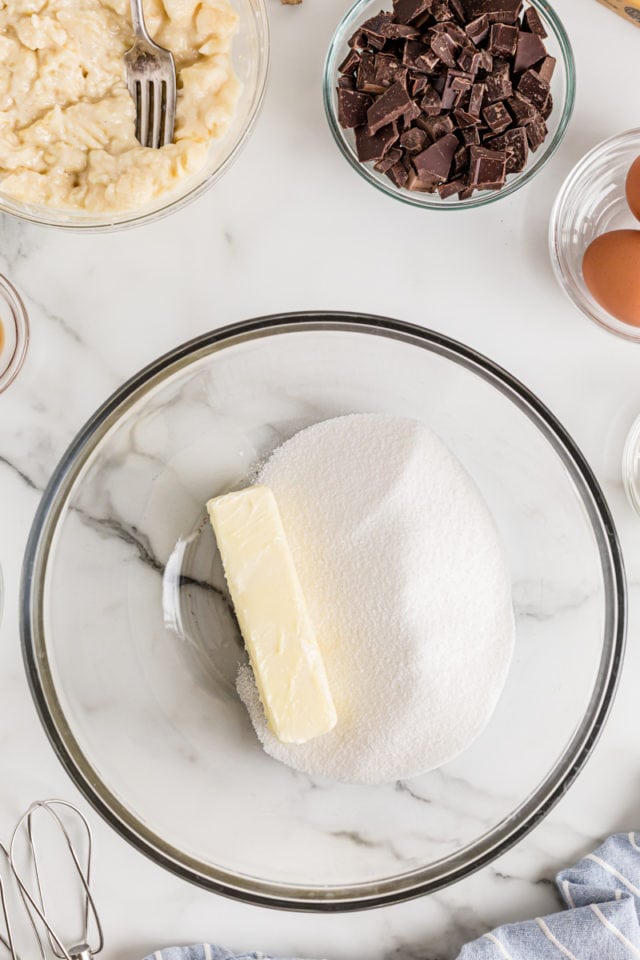 Stick of butter and sugar in glass mixing bowl